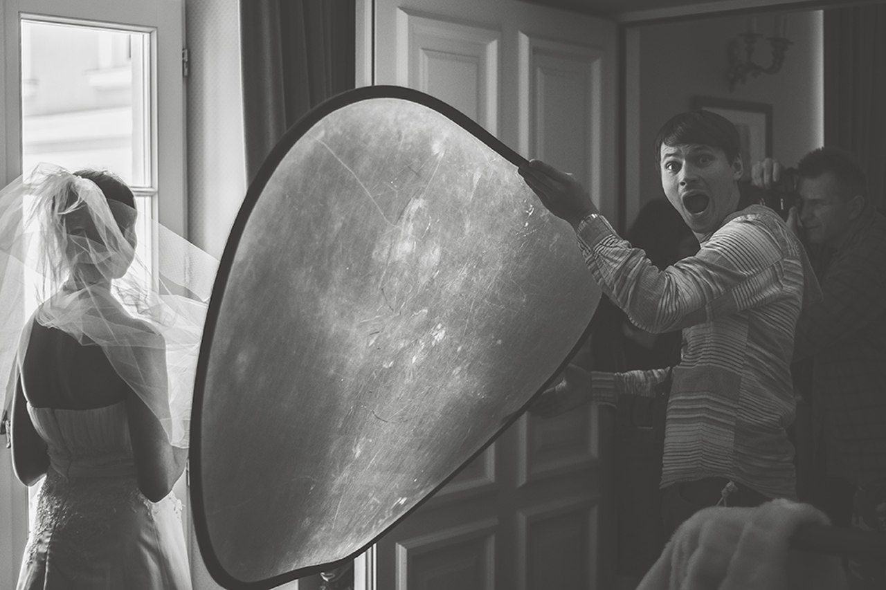 Fotograf ślubny trzyma blendę