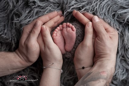 stópki noworodka w rękach rodziców