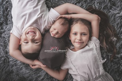 rodzeństwo na zdjęciu z noworodkiem