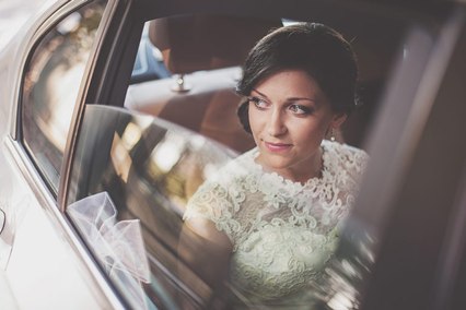 Panna Młoda wygląda przez szybę limuzyny