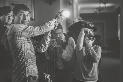 fotograf ślubny trzyma światło na planie zdjęciowym