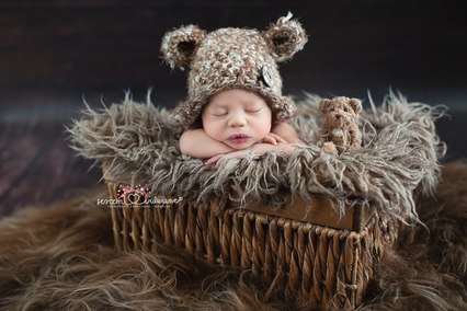 w brązowym koszu chłopiec na sesji noworodkowej