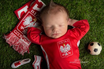 Noworodek w stroju Reprezentacji Polski, szalik kibica, piłka i buty, stylizacja piłkarska na trawie