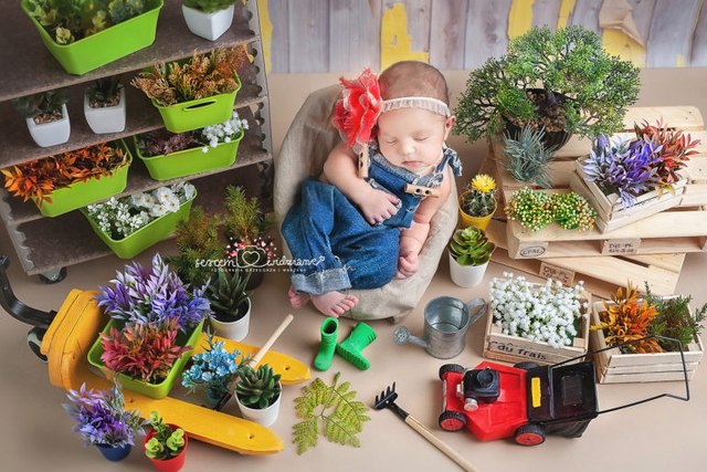 Mała dziewczynka ogrodniczka na sesji noworodkowej