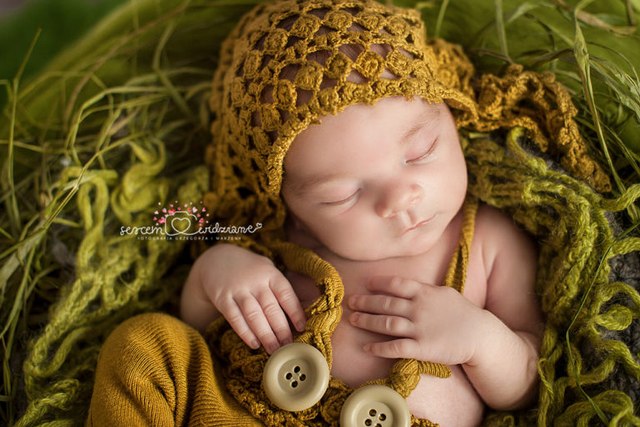 chłopczyk podczas sesji noworodkowej leży w kocykach