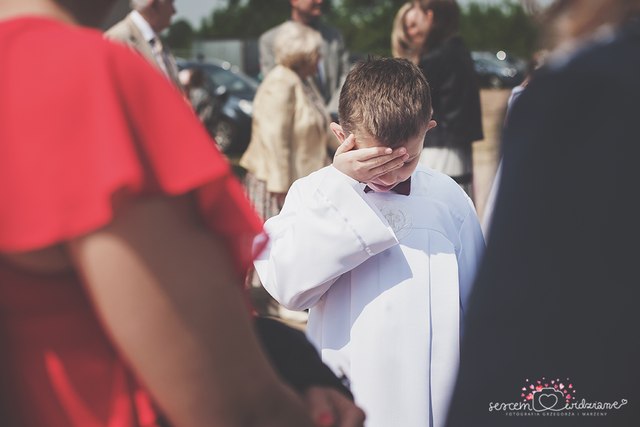 chłopiec przed kościołem na Komunii