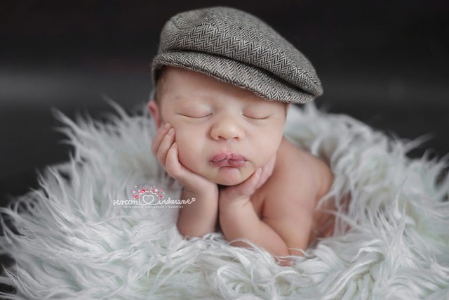 chłopczyk na rączkach na noworodkowej sesji zdjęciowej